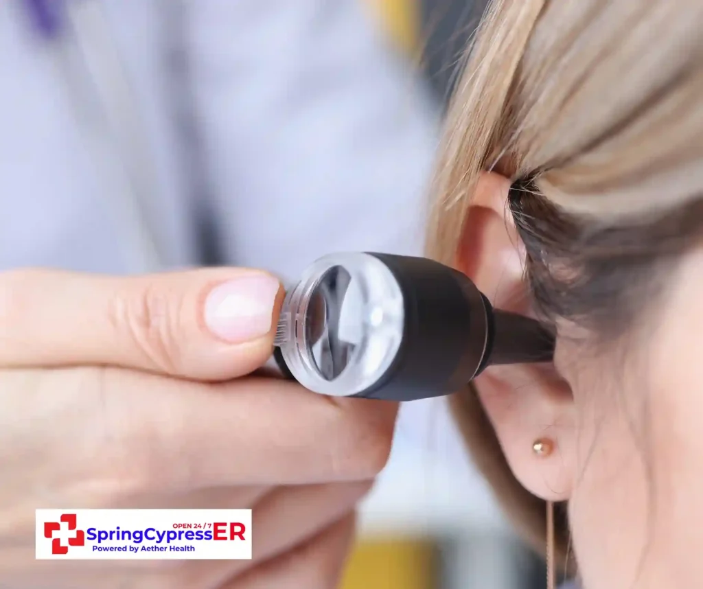 Doctor performing an ear exam for urgent care needs at Aether Health - Spring Cypress ER