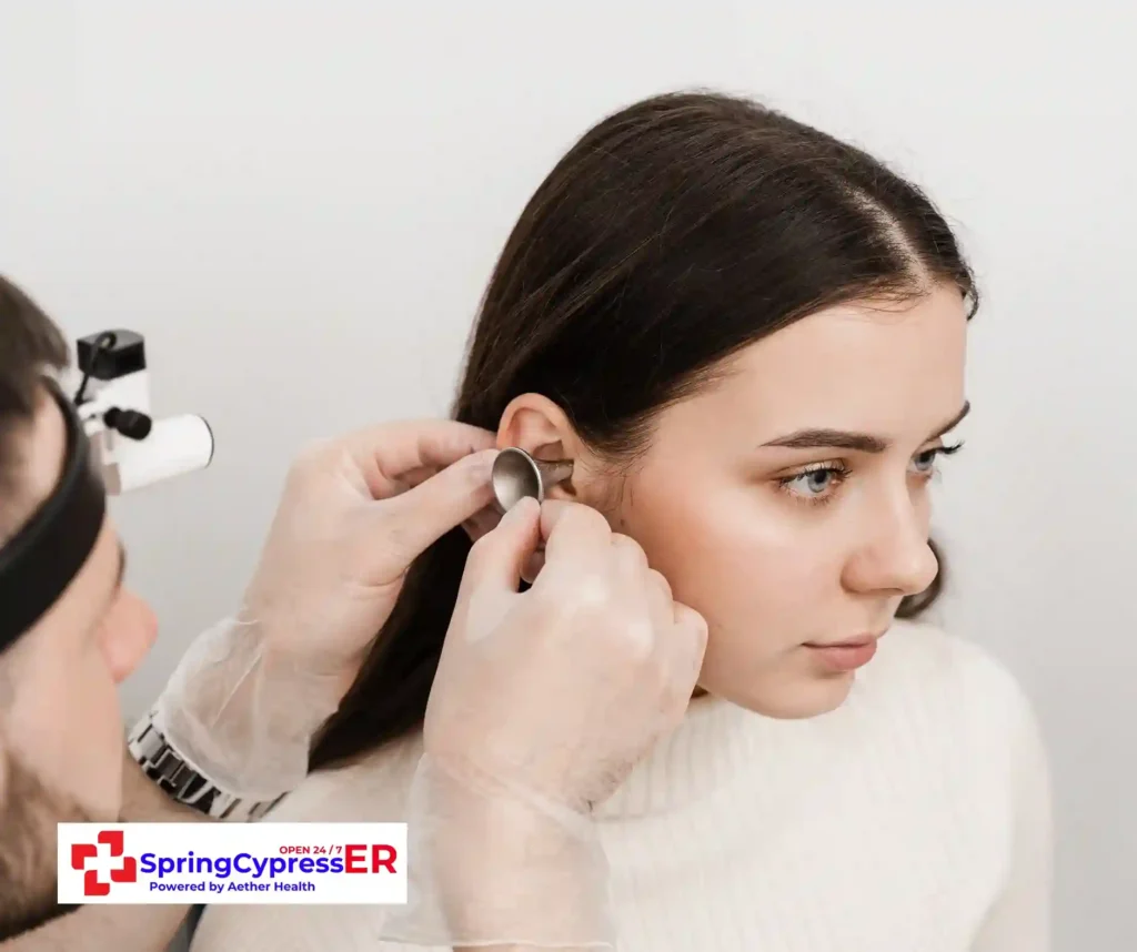 Doctor performing an ear exam for urgent care needs at Aether Health - Spring Cypress ER